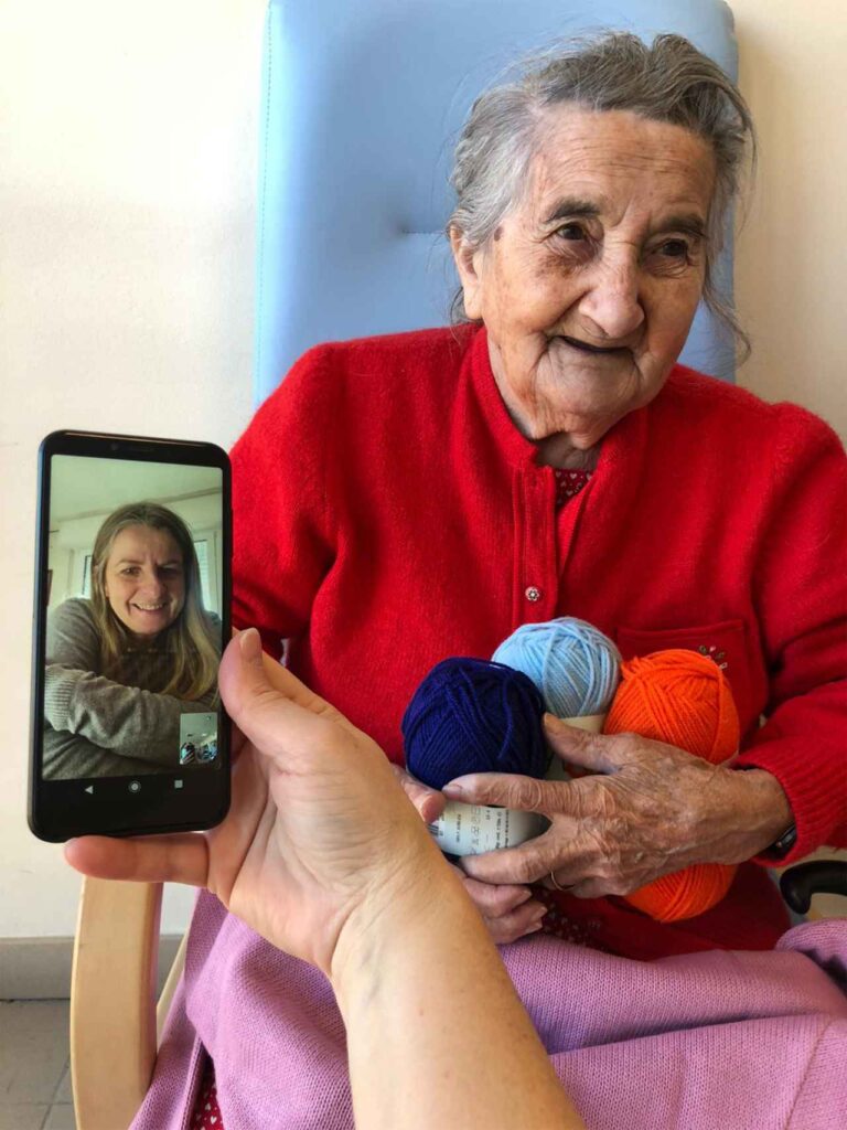 Anziana con gomitoli donati da una nipote di Babbo Natale