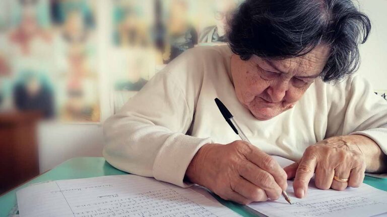 Anziana che scrive una lettera con il progetto Nipoti di Penna