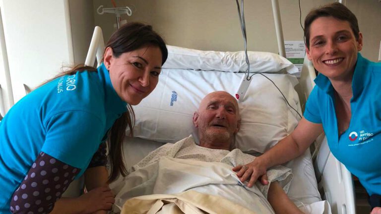 Due volontarie Un Sorriso in Più con anziano a letto in ospedale